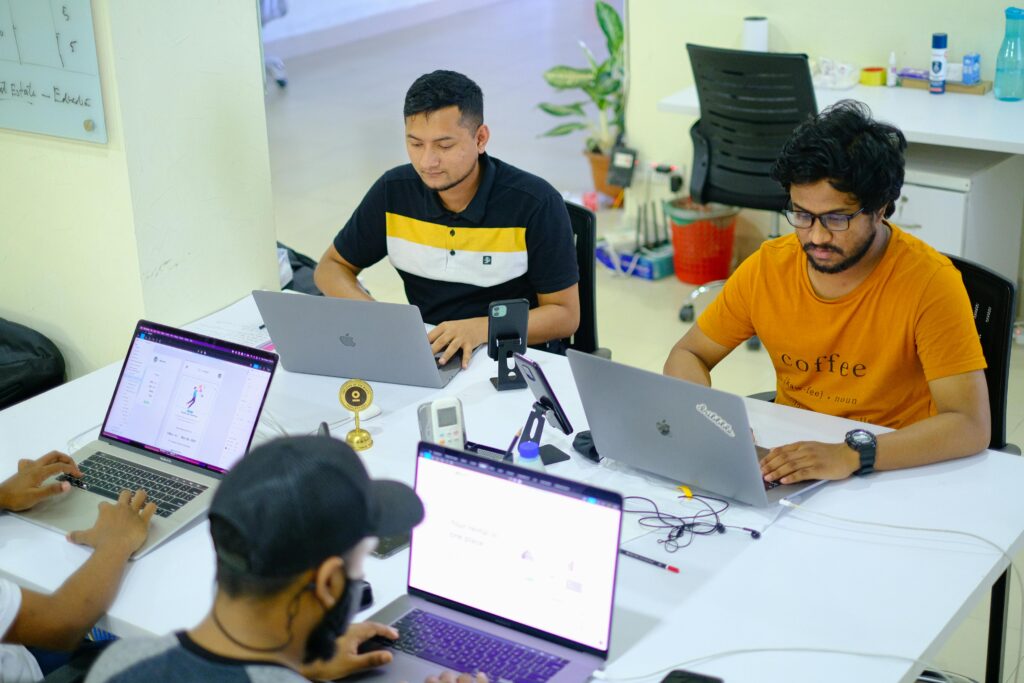 High-Angle Shot of Four Men Using Laptops in the Office